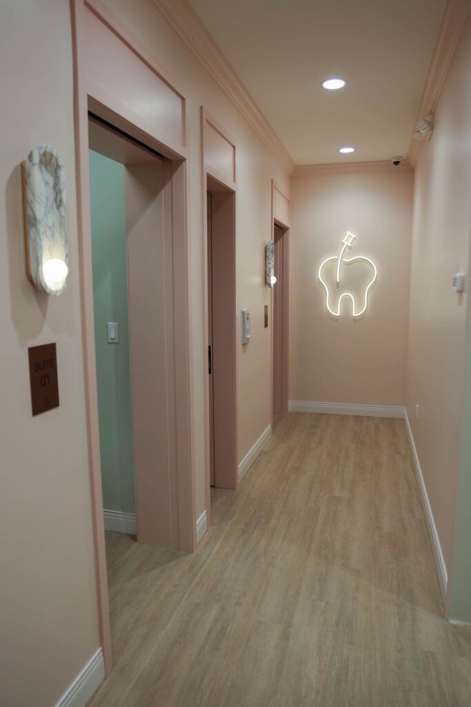 Elite Orthodontics Studio office hallway with a glowing tooth sign at the end