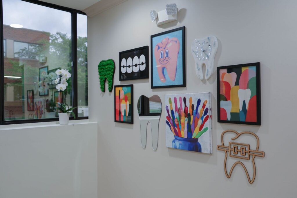 Elite Orthodontics Studio office wall of colorful framed tooth artwork